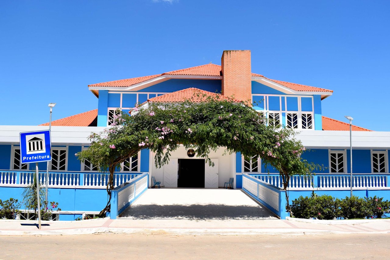 Fachada azul de um prédio público municipal em Santa Maria de Jetibá, no Espírito Santo, sob céu claro.