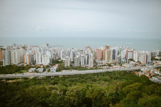Vista aérea panorâmica da área urbana de Vitória, com edifícios, áreas verdes e faixa litorânea
